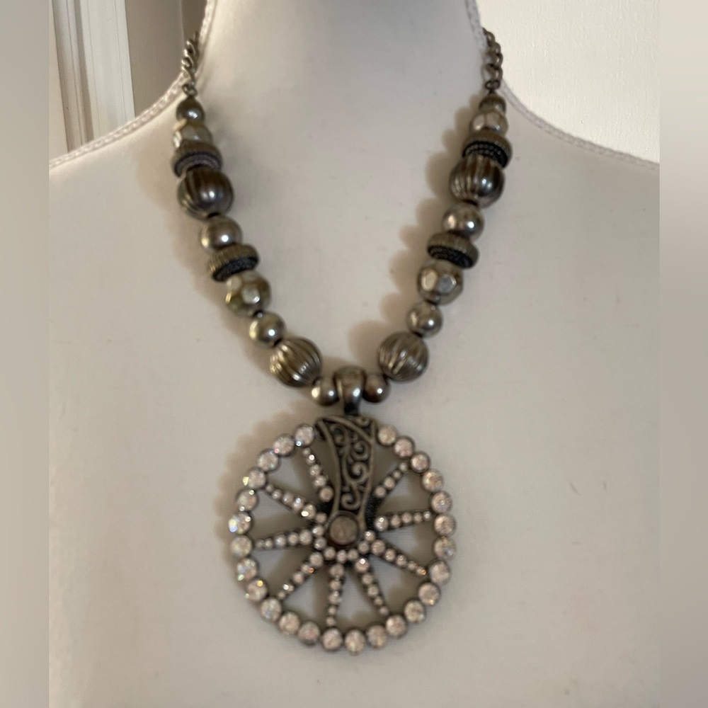 Silver tone beaded necklace with spur pendant.